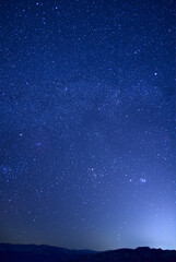 Obraz premium 山のシルエットと満天の星空。