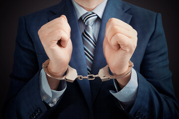 Businessman arrested, man in suit with handcuffs