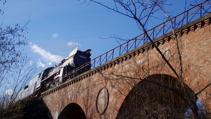 Steam locomotive on the old retro brick bridge