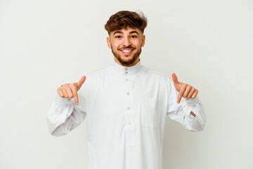 Young Moroccan man wearing a typical arab clothes isolated on white background points down with fingers, positive feeling.