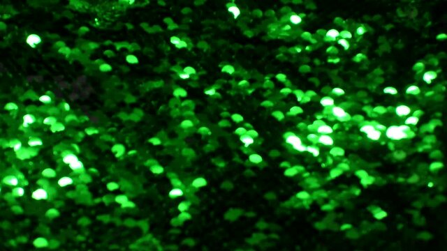 Blurred abstract colorful texture of bright sequins. Glamor background with glittering multi-colored sequins on fabric, macro. Beautiful bright wallpaper with a pattern of round sequins.