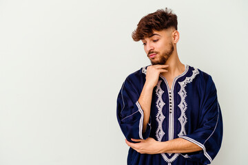 Young Moroccan man isolated on white background looking sideways with doubtful and skeptical expression.