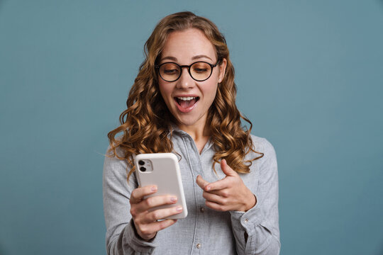 Cheerful young girl usig mobile phone isolated
