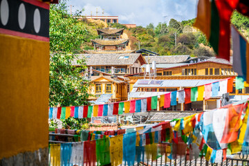 Houses and temple view between prayer flags in Dukezong old town Shangri-La Yunnan China