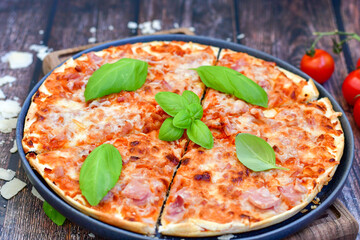  Close up of    hot italian pizza   classic ham. Fresh basil,tomato sauce ,mozzarella cheese , mushrooms and  minced meat .Concept poster for Restaurants or pizzerias. Top view