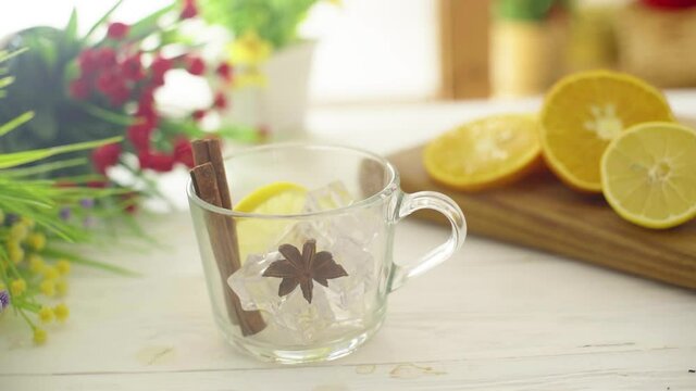 Tea is poured into a glass transparent cup on a wooden table