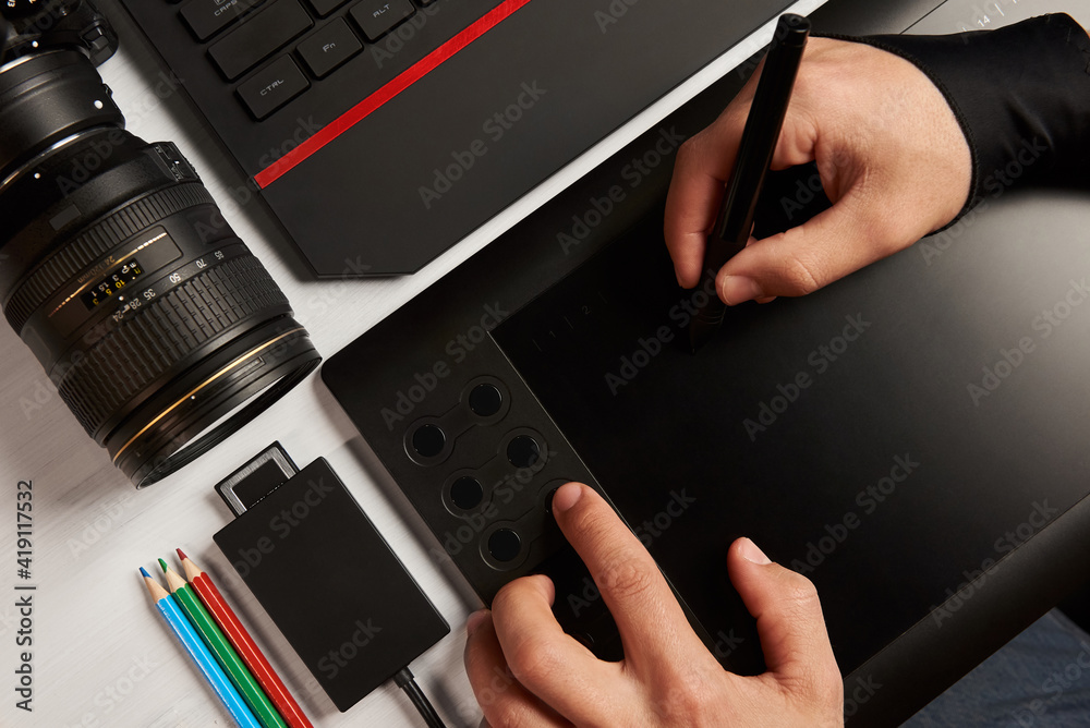 Fototapete top view of photographer's desktop. hands working on a graphics tablet