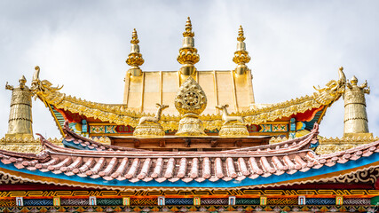 Fototapeta premium Golden roof details with Dharma wheel of Baiji or one hundred chicken Tibetan Buddhist temple Shangri-La Yunnan China