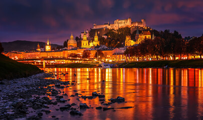 Fantastic colorful evening view on Salzburg historical city. Castle Hohensalzburg with night street light and perfect reflection. concept ideal resting place. Popular travel and historical center.