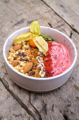 Healthy food Strawberry breakfast superfoods smoothie bowl with chia seeds, bee pollen, fresh Strawberry, almond and granola for healthy vegan
