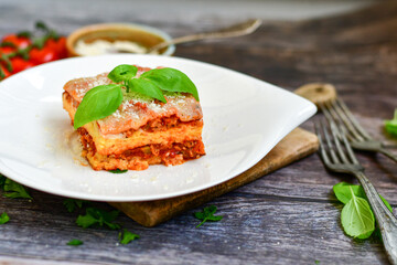   Delicious Home made keto diet  Lasagna bolognese  with  Lupin Flour, minced meat,tomato sauce and spinach  on a wooden rustic  background.Home made low carb italian meal