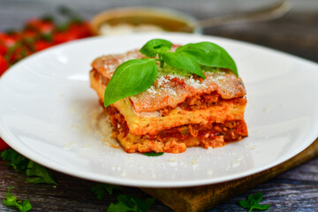   Delicious Home made keto diet  Lasagna bolognese  with  Lupin Flour, minced meat,tomato sauce and spinach  on a wooden rustic  background.Home made low carb italian meal