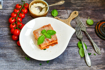  Delicious Home made keto diet  Lasagna bolognese  with  Lupin Flour, minced meat,tomato sauce and spinach  on a wooden rustic  background.Home made low carb italian meal