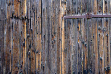 Ancient shutters on the window of an old house with metal pegs. Background. Close-up. copy space	
