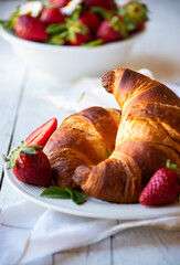 Croissants with strawberry jam and fresh fruit, delicious and healthy breakfast