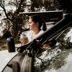 A woman with her drink camping