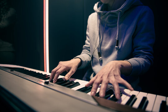 A woman plays the musical keys in the studio close up.