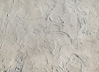 The effect of decorative, rounded plaster, made with trowel strokes on the wall. Light gray background, copy space.