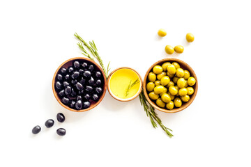 Top view of green and black olives in bowls with oil