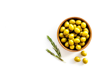 Wooden bowl of pickled green olives, top view