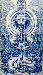 Fototapeta na wymiar Portuguese traditional tiles Azulejos forming blue mosaic on a white background, which depicts lion holding a stand with two snakes, wings and flowers.