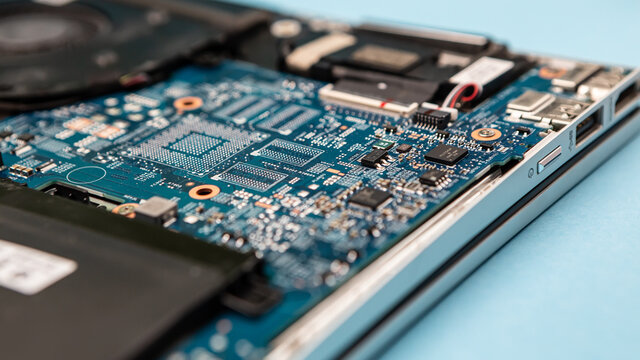 Close up laptop without cover inside disassembling in repair shop. Computer service engineer technician workplace repairing fixing broken components upgrade system, microelectronics maintenance
