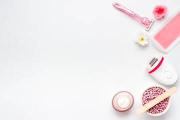 Cosmetics set for epilation with epilator and wax strips and flowers. Top view