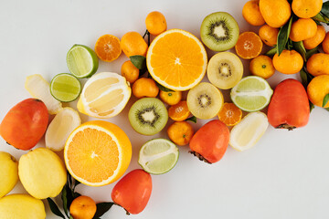 Pile of juicy green and orange ripe fruits like kiwi, oranges, limes and lemos with madnarines