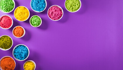 Happy holi festival decoration.Top view of colorful holi powder on purple  background with copy...