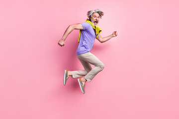 Full length profile side photo of mature man jump go walk run hurry tied sweater isolated over pastel color background
