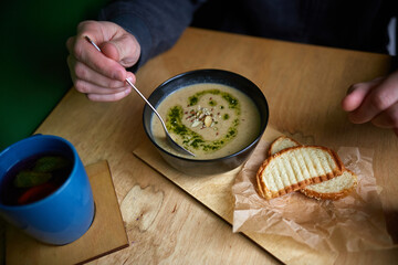 man eating Creamy Broccoli Soup with Croutons. Healthy food