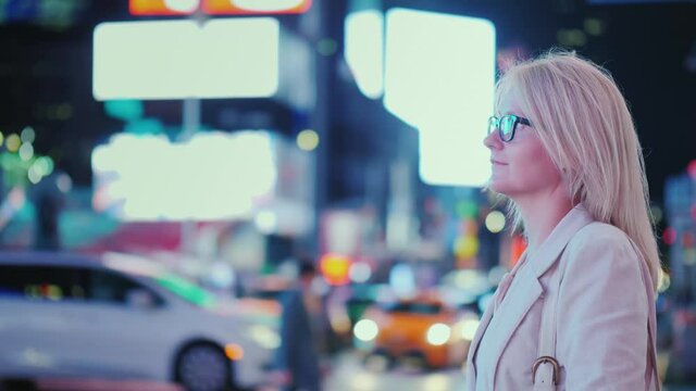 Tourist looks at the bright lights of advertising on Times Square in the heart of New York
