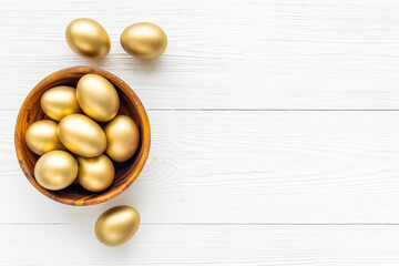 Golden eggs in wooden bowl. Wealth and good luck concept. Easter decoration
