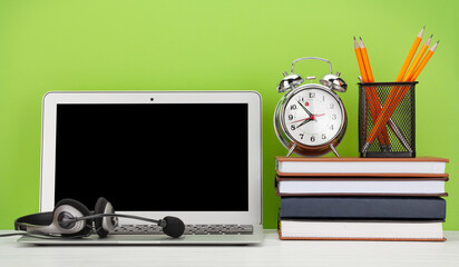 Office desk with headset and laptop. Work from home