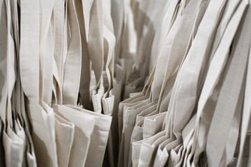 Eco-bags in a natural shade, hanging in the store. Natural products, no waste