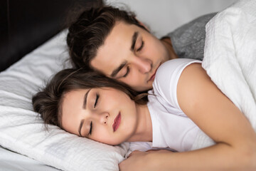 Young lovely hug couple sleep in a bed,