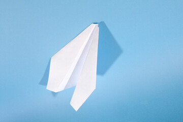 White paper airplane with shadow. Airplane on a blue background