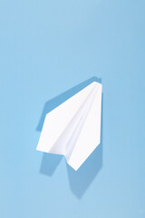 White paper airplane with shadow. Airplane on a blue background