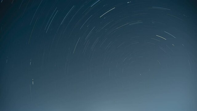 Stars are moving around Polaris. Faint star trail due to heavy light pollution in the city. 4k long exposure night sky atmosphere background Video.