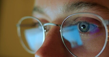 Close up macro shot of reflection in glasses. Young woman with beautiful blue eyes look at screen of laptop or desktop computer. Processing of big data and internet information - Powered by Adobe