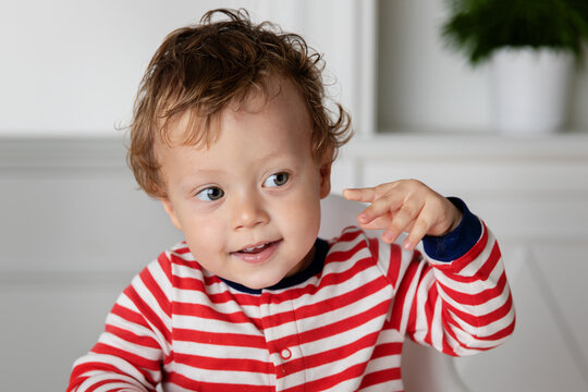 Cute toddler touching his ear with his finger