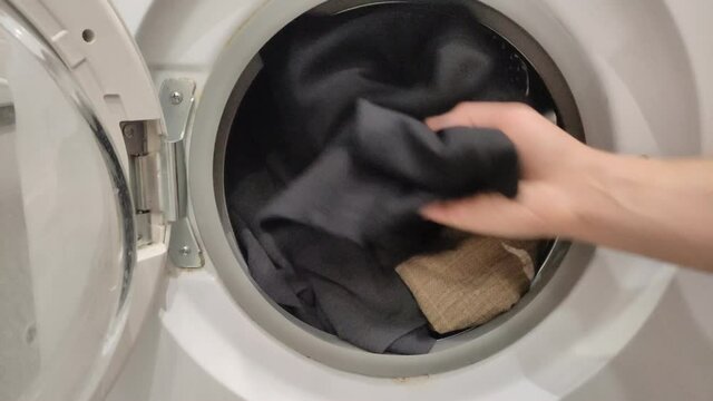 Housekeeper loading dirty laundry into the washing machine