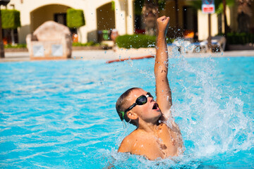 Naklejka premium Active lifestyle of Happy boy with goggles in the swimming pool Summer vacation