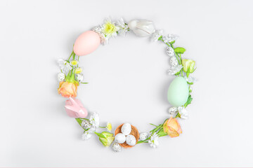 Creative layout composition of flowers and easter eggs on pastel background.