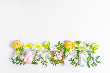 Creative layout composition of flowers and easter eggs on pastel background.