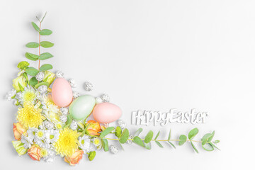 Creative layout composition of flowers and easter eggs on pastel background.