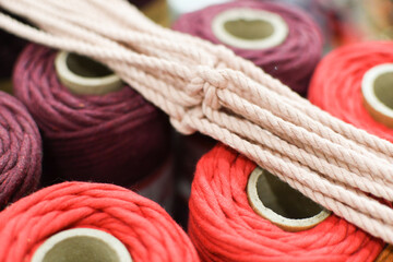Colored cotton rope.
Yarn spools. Side view. Assorted textile spools. Macrame rope