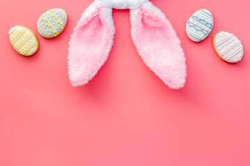 Top view of Easter bunny ears with eggs cookies, space for text