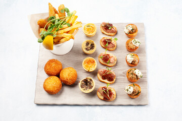 Canapés on a board with fries in a restaurant