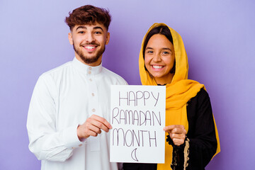 Young Moroccan couple wearing a typical arabic costume celebrating Ramadan isolated on purple background
